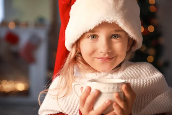 Menina bonito com chocolate quente na véspera de Natal em casa — Fotografia de Stock