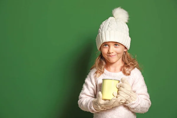 Menina bonito com xícara de chocolate quente no fundo de cor — Fotografia de Stock