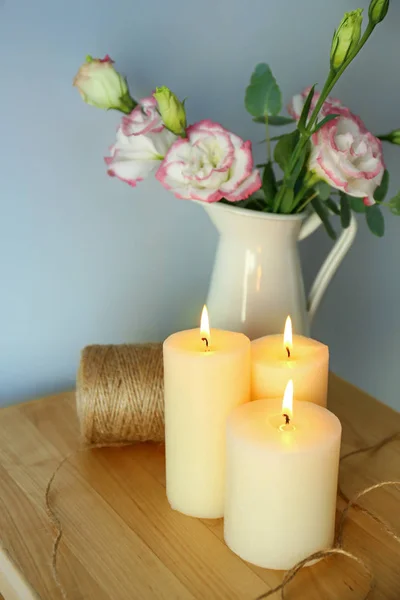 美丽的燃烧蜡烛与线程和花在木桌上的壶 — 图库照片