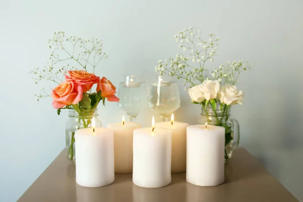 Lindas velas acesas com flores de rosas na mesa — Fotografia de Stock