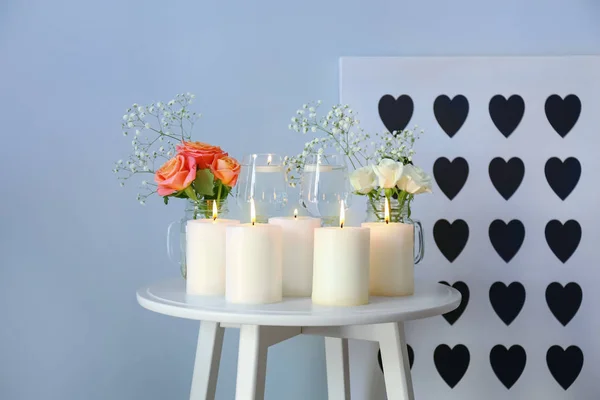 Beautiful burning candles with rose flowers on table — Stock Photo, Image