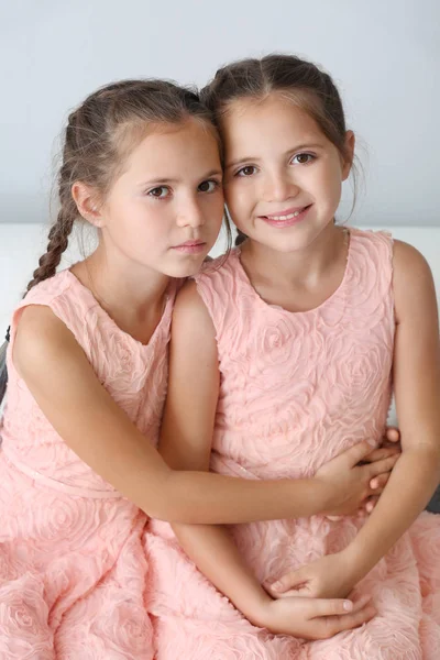 Hafif arka planda sevimli ikiz kız Portresi — Stok fotoğraf