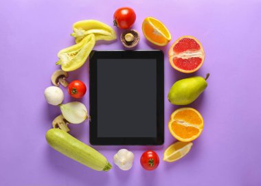 Tablet bilgisayar ve renkli arka planda taze ürünler