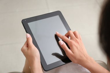 Evde tablet bilgisayarı olan genç bir kadın.