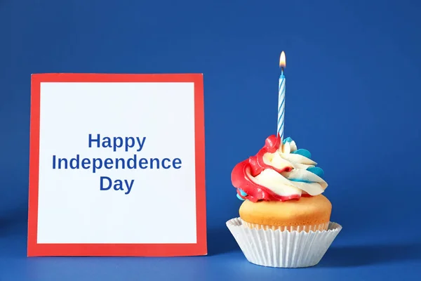 Smakelijke patriottische cupcake en kaart met tekst gelukkig Onafhankelijkheidsdag op kleur achtergrond — Stockfoto