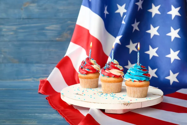 Tasty patriotic cupcakes and USA flag on table — Stock Photo, Image