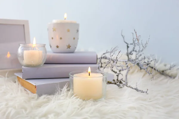 Composition with beautiful burning candles and books on fluffy plaid — Stock Photo, Image