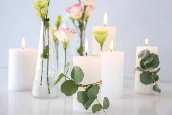 Композиция с красивыми горящими свечами и цветами на столе — стоковое фото