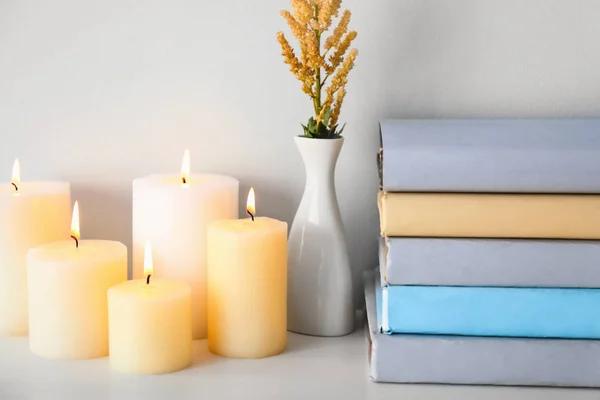 Composição com belas velas em chamas e livros na mesa — Fotografia de Stock