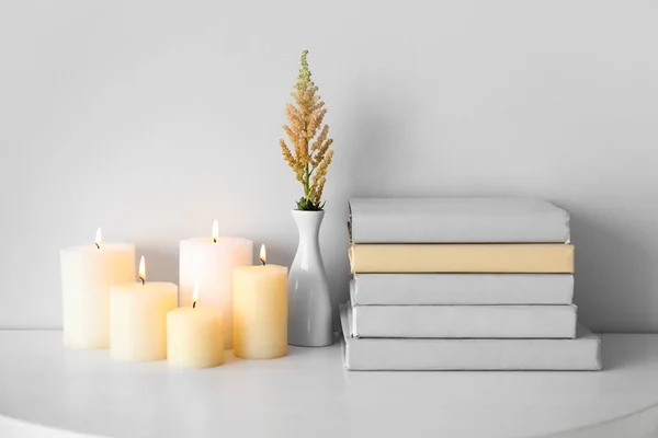 Composition with beautiful burning candles and books on table — Stock Photo, Image