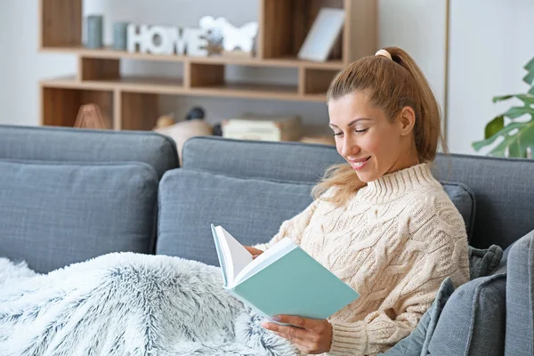 Piękna młoda kobieta czyta książkę w domu — Zdjęcie stockowe