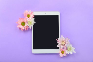 Modern tablet bilgisayar ve renkli arka planda çiçekler