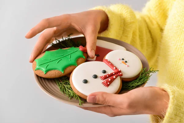 Женщина с вкусным рождественским печеньем на тарелке, крупным планом — стоковое фото