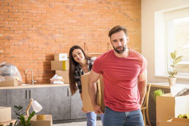 Yeni eve taşındıktan sonra kutuları taşıyan genç çift