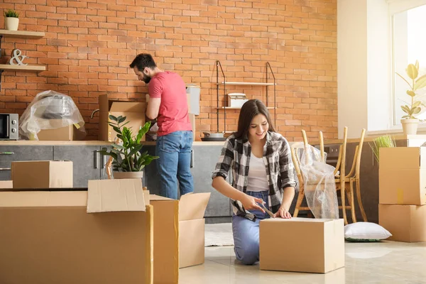 Молода пара розпаковує речі після переїзду в новий будинок — стокове фото