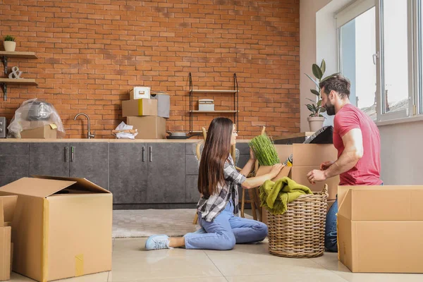 Pareja joven desempacando cosas después de mudarse a casa nueva — Foto de Stock