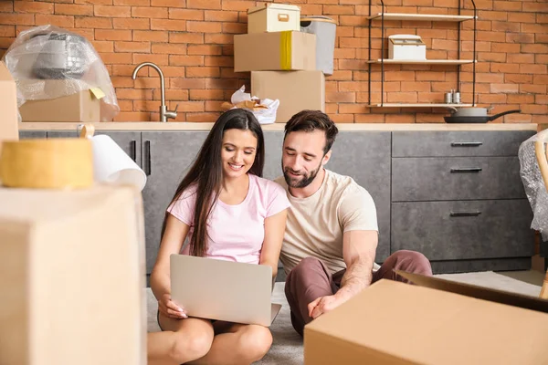 Pareja joven con diseño de planificación portátil de su nueva casa — Foto de Stock