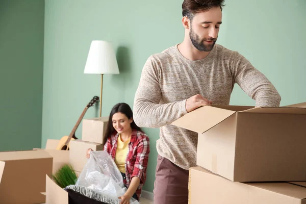 Young couple unpacking things after moving into new house — Stock Photo, Image