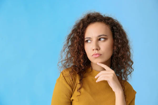 Tankeväckande afro-amerikansk kvinna på färg bakgrund — Stockfoto