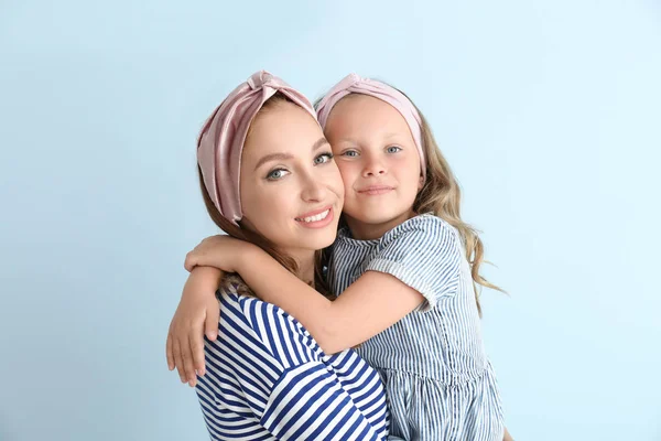 Beautiful woman and her little daughter on color background — Stock Photo, Image