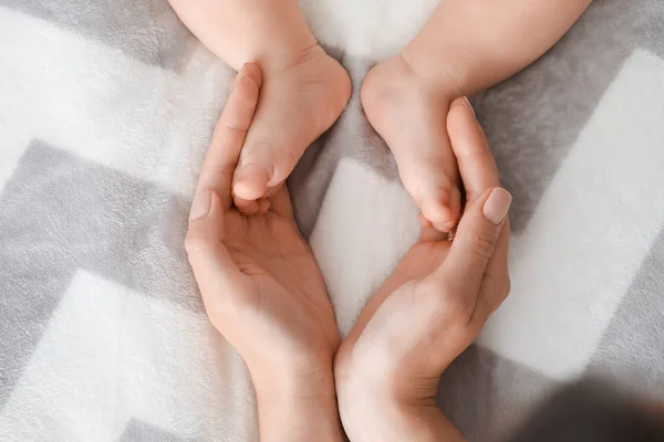 Madre tocando los pies de su lindo bebé, primer plano —  Fotos de Stock