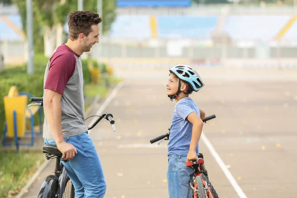 Feliz padre e hijo montando bicicletas al aire libre —  Fotos de Stock