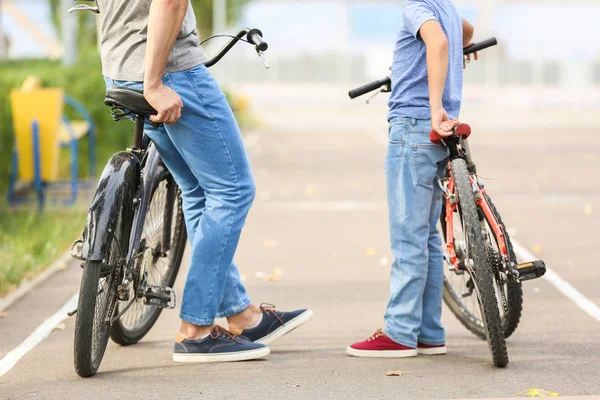 Lycklig far och son ridning cyklar utomhus — Stockfoto