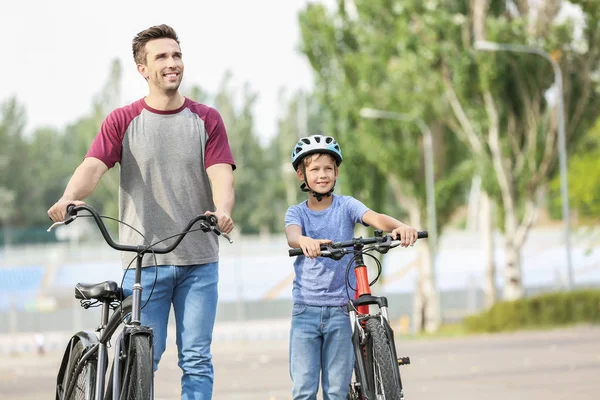 Ευτυχισμένος πατέρας και γιός ιππασία ποδήλατα σε εξωτερικούς χώρους — Φωτογραφία Αρχείου
