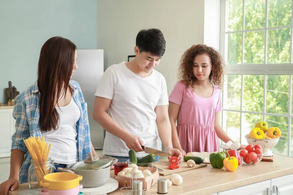 Glückliche Freunde kochen gemeinsam in der Küche — Stockfoto