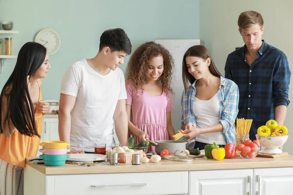 Glückliche Freunde kochen gemeinsam in der Küche — Stockfoto