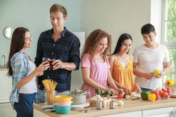 Happy friends cooking together in kitchen — Stock Photo, Image