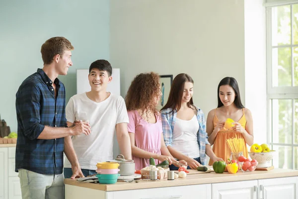 Amigos felices cocinando juntos en la cocina — Foto de Stock