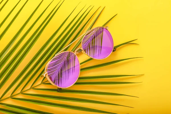 时尚的太阳镜，带棕榈叶的颜色背景 — 图库照片