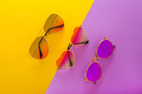 Diferentes gafas de sol elegantes sobre fondo de color —  Fotos de Stock