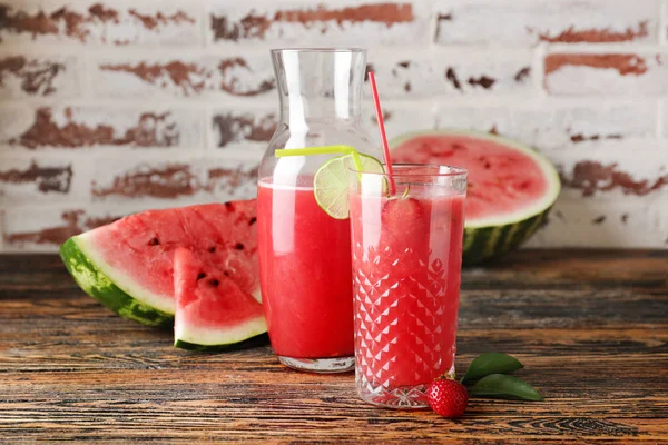 Vaso y botella de jugo de sandía fresca en la mesa —  Fotos de Stock