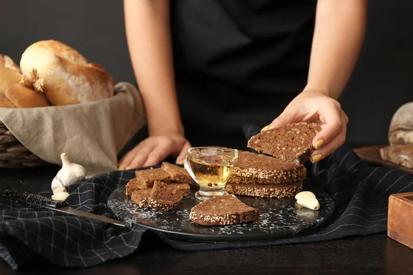 Woman with slices of fresh bread, oil and spices on table — Stock Photo, Image