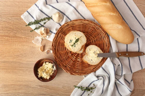 Slices of fresh bread with butter, herbs and garlic on table — Stock Photo, Image