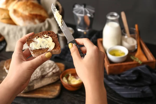 Donna che spalma burro sulla fetta di pane fresco, primo piano — Foto Stock