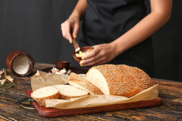 Donna che spalma burro sulla fetta di pane fresco, primo piano — Foto Stock