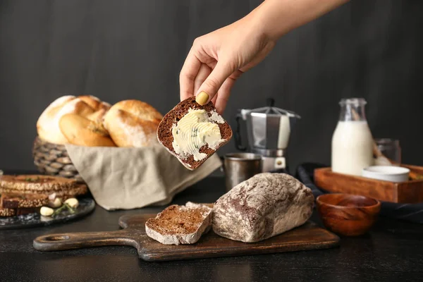 Donna che prende fetta di pane fresco con burro dalla tavola — Foto Stock