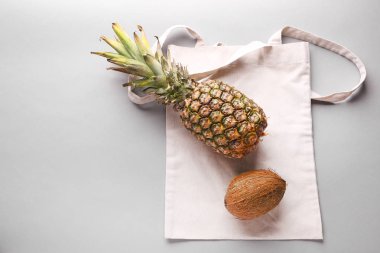 Gri arka plan üzerinde ananas ve hindistan cevizi ile Eko çanta