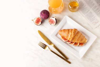 Masada tatlı kruvasan ve incir meyve dilimleri ile Tabak