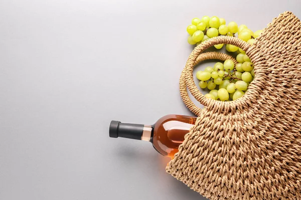 Эко-сумка с бутылкой вина и винограда на сером фоне — стоковое фото