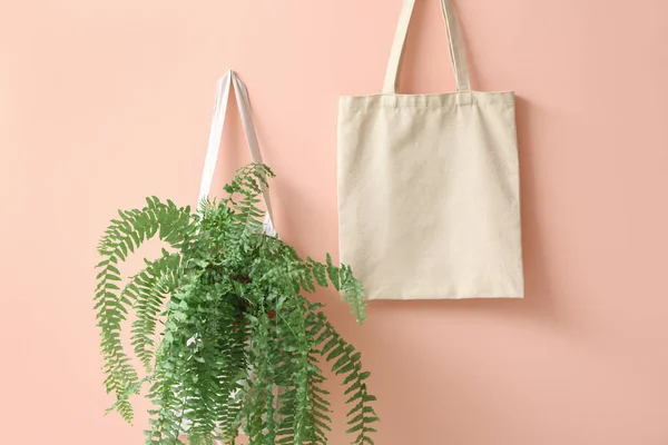 Eco sacos com planta sobre fundo de cor — Fotografia de Stock