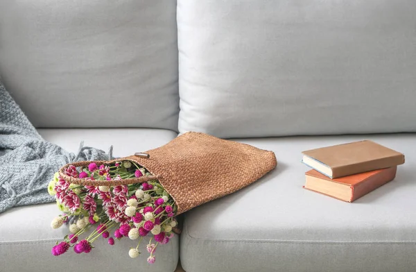 Saco Eco com flores e livros no sofá — Fotografia de Stock