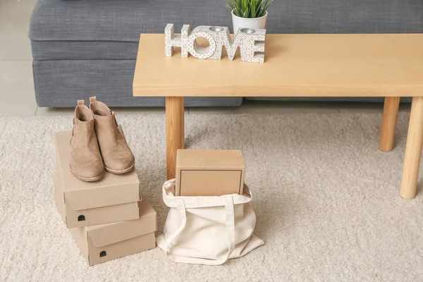 Sac écologique avec boîtes et chaussures féminines sur le sol dans la chambre — Photo