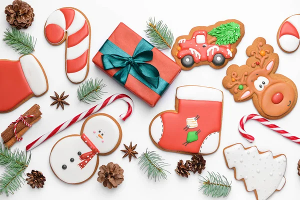 Smaczne ciasteczka świąteczne z prezentem na białym tle — Zdjęcie stockowe