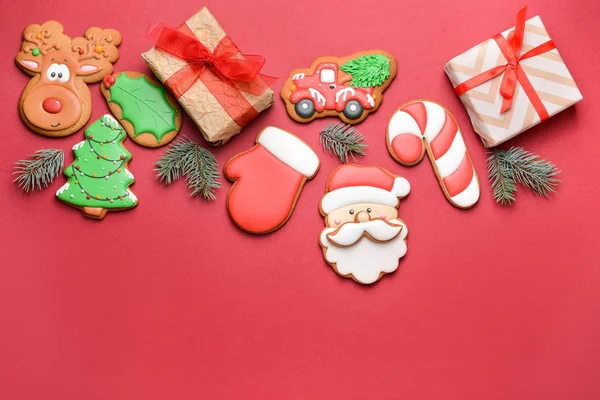 Tasty Christmas cookies with gifts on color background — Stock Photo, Image