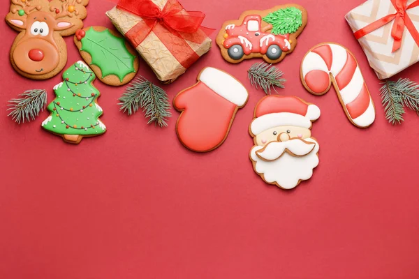 Tasty Christmas cookies with gifts on color background — Stock Photo, Image