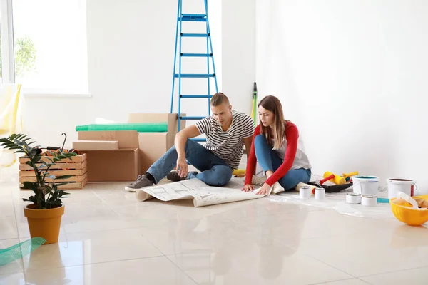 Glückliches junges Paar plant Reparatur im neuen Haus — Stockfoto